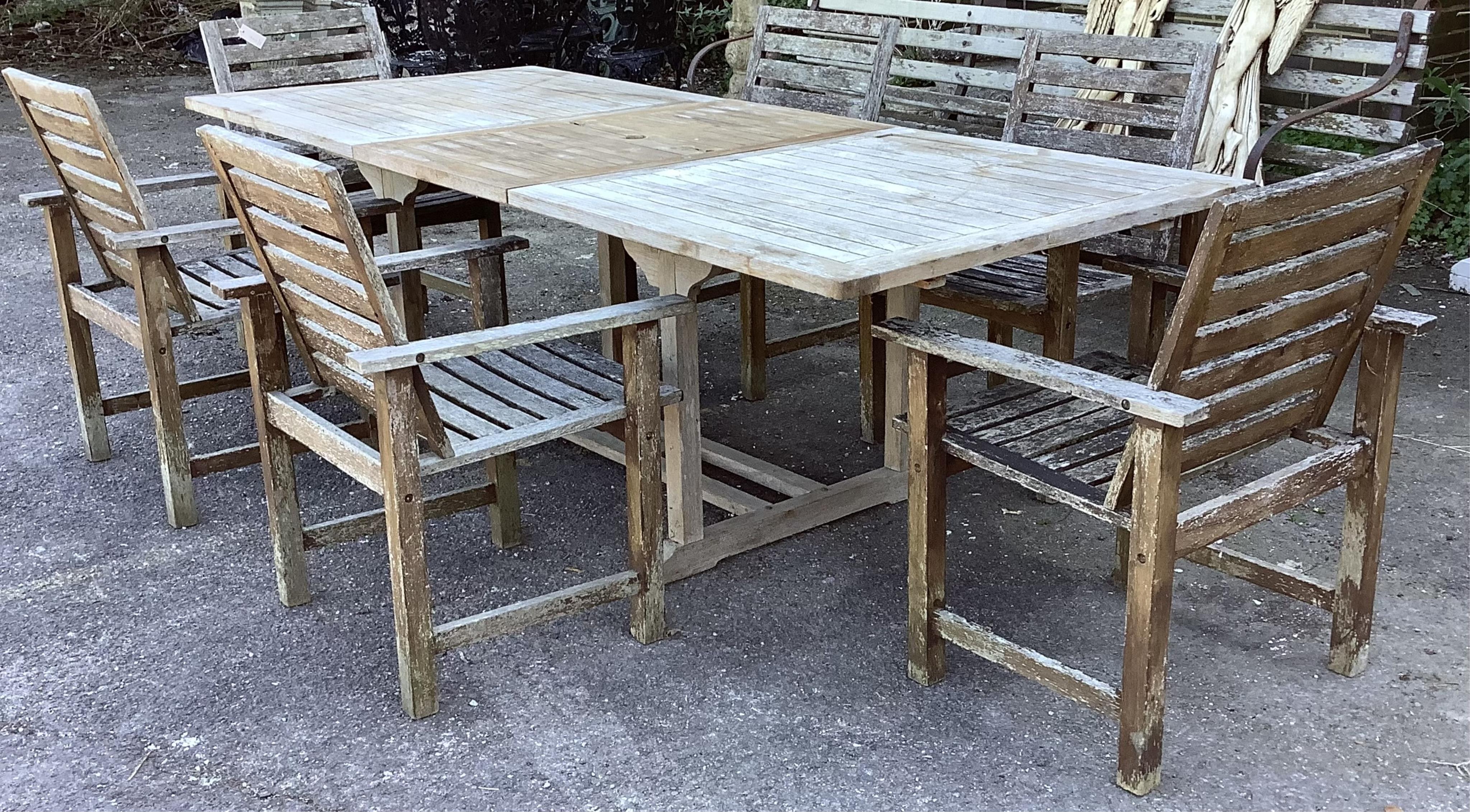A rectangular weathered teak extending garden table, width 240cm extended, depth 100cm, height 74cm together with six weathered teak garden chairs. Condition - fair, table leaf has large chip